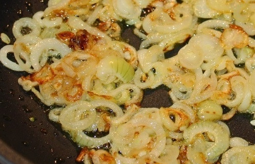 1. Этап. Солянка с креветками: 11. На сковороде растопите сливочное масло. Выложите нарезанный кольцами или полукольцами лук и обжарьте его до легкого золотистого цвета.