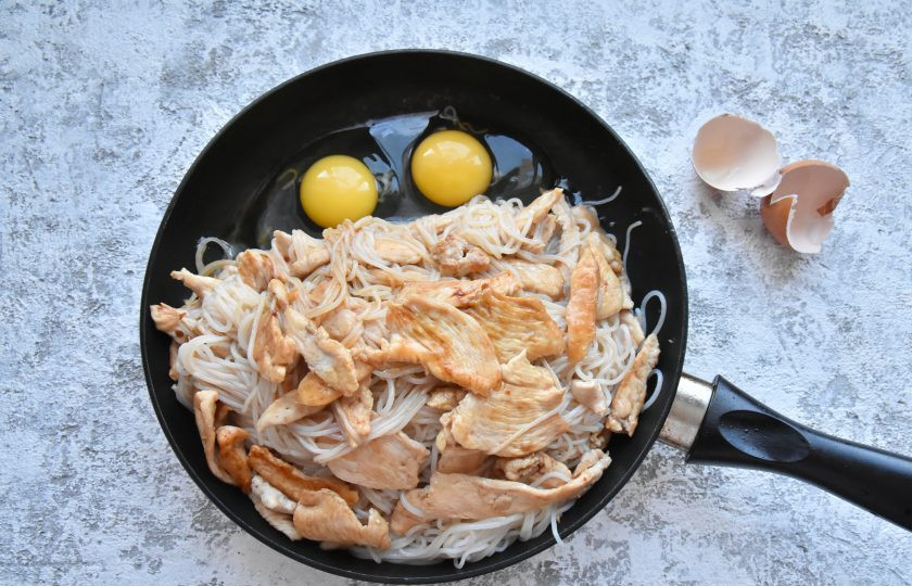 1. Этап. Рисовая жареная лапша Пад Тай: Сдвиньте лапшу на край сковороды и в освободившееся пространство вбейте яйца.