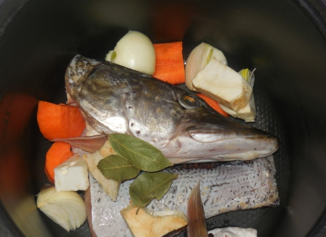 1. Этап. Уха из щучьих голов: В чашу мультиварки выложите морковь, перец, лук, щуку, лавровый лист и сельдерей. Затем влейте воду. Поставьте режим 