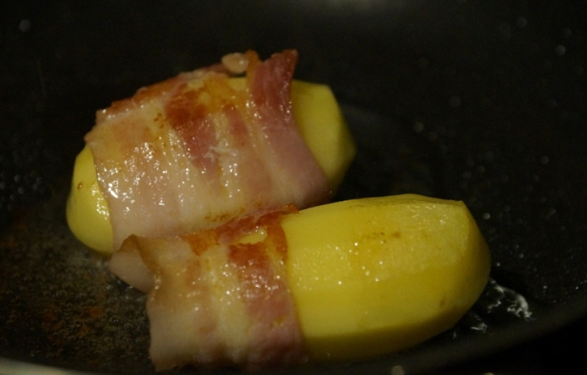 1. Этап. Кролик по-испански: Отварной картофель оберните полосками бекона, обжарьте на растительном масле до золотистого цвета.