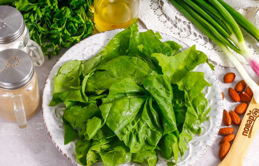 1. Этап. Салат с миндалем и курицей: Промойте пучок шпината, срежьте стебли и слегка просушите его бумажными салфетками. Выложите листья на тарелку. Можно использовать вместо шпината листовой салат.
