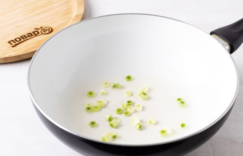 1. Этап. Салат Китайский с кукурузой: Разогрейте растительное масло в сковороде вок и обжарьте белую часть лука 1 минуту.