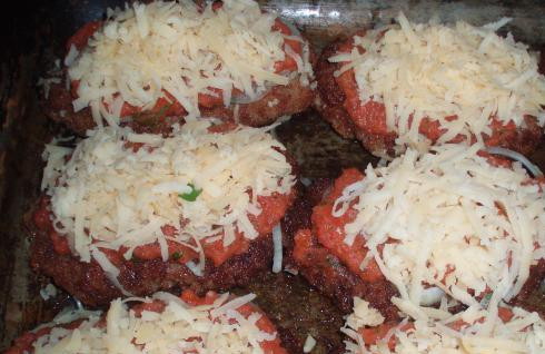 1. Этап. Шницель говяжий: Формируем из фарша большие и тонкие котлетки, слегка обжариваем их на сковороде и кладем на противень. Для соуса: измельчаем в блендере помидоры и чеснок, добавляем туда же томатный соус и специи. Получается густой томатный соус. Кладем на шницели: порезанный колечками лук, поливаем томатным соусом, присыпаем тертым сыром. Запекаем в духовке до красивой румяной корочки, примерно 20-25 минут.