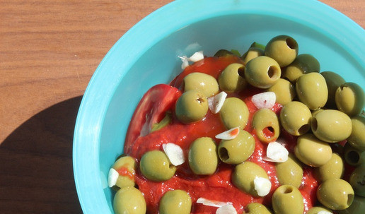 1. Этап. Салат-закуска Под шашлычок: Оливки отцедить и добавить к салату. Чеснок нарезать очень тонкими пластинками.