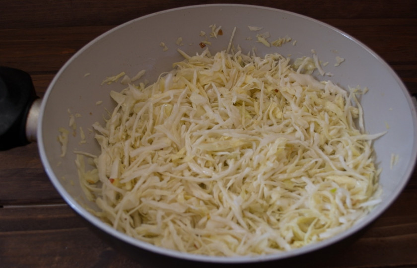 1. Этап. Дрожжевые пирожки с капустой: На растительном масле обжарьте мелко нарезанный репчатый лук. Добавьте капусту. Накройте крышкой и обжаривайте на небольшом огне около 10 минут. Периодами помешивайте, чтоб капуста не подгорела. Можно влить воды, чтоб ускорить процесс.