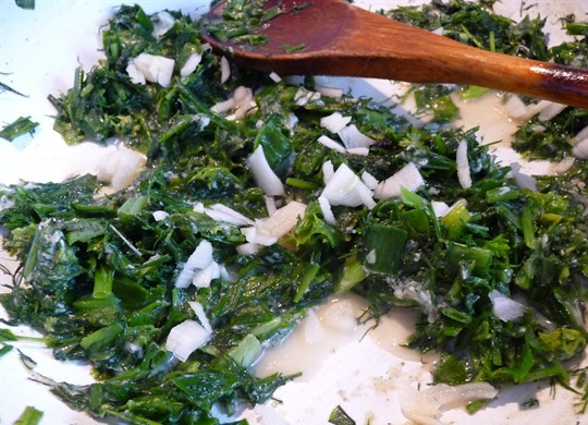 1. Этап. Постные лепешки с зеленью: 3. На сковороду налить немного растительного масла и отправить туда зелень. Обжарить на среднем огне пару минут, чтобы зелень стала мягче. Очистить чеснок и нарезать мелко. Добавить на сковороду, перемешать и можно снять с огня. Как следует остудить.