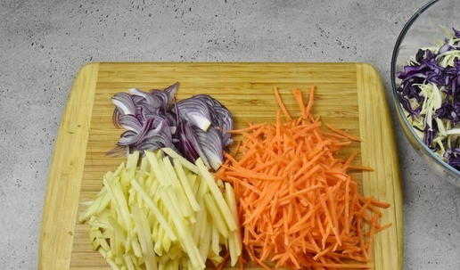 1. Этап. Коул слоу с индейкой: Морковь натрите на терке для корейских салатов. Нарежьте перьями красный лук и соломкой яблоко.