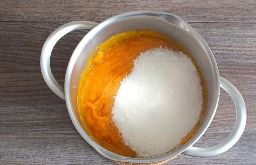1. Этап. Повидло из тыквы с курагой: Добавьте к полученному пюре сахар. Поставьте кастрюлю на медленный огонь. Варите под крышкой, с момента закипания, 25 минут.