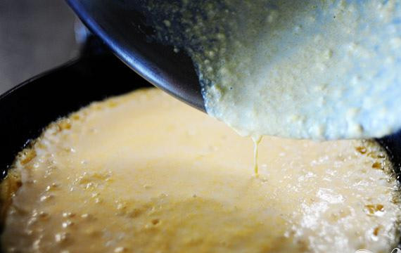 1. Этап. Кукурузный хлеб: 5. В большой сковороде растопить оставшиеся 2 столовые ложки растительного жира на среднем огне. Вылить приготовленное тесто в горячую сковородку. Выровнять поверхность большим шпателем. Тесто должно зашипеть.