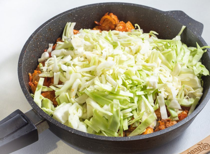 1. Этап. Рис с мясом и капустой в сковороде: По истечении времени добавьте капусту на сковороду и влейте примерно 0,5 стакана воды. Перемешайте и тушите под крышкой около 10 минут.