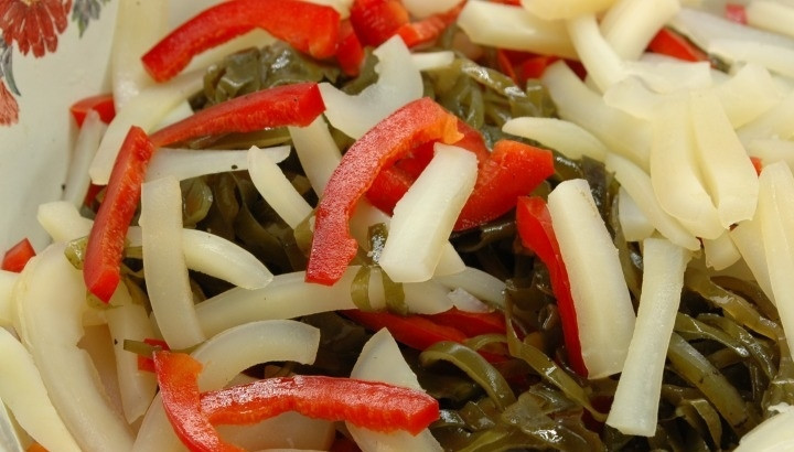 1. Этап. Морской салат с кальмарами: 2. Кальмары у меня очищенные и охлажденные, нарезаю их тонкими полукольцами. В кастрюлю наливаю воду, довожу до кипения, после этого отправляю кальмары и отвариваю их 2 минуты. В салатник кладу кальмары, морскую капусту и болгарский перец.