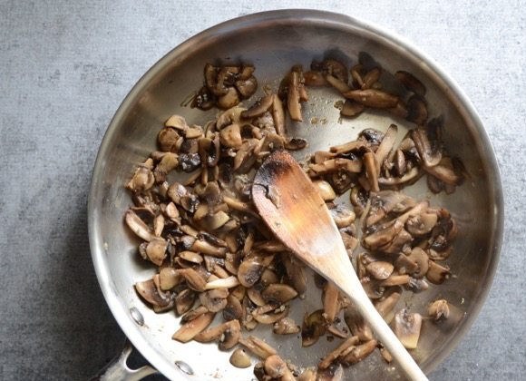 1. Этап. Бутерброды в духовке с грибами и шпинатом: 1. В сковороде разогрейте столовую ложку растительного масла. Измельчите чеснок и обжарьте его 30-60 секунд. Нарежьте кусочками грибы и выложите их в сковороду, посолите и обжарьте до золотистой корочки.