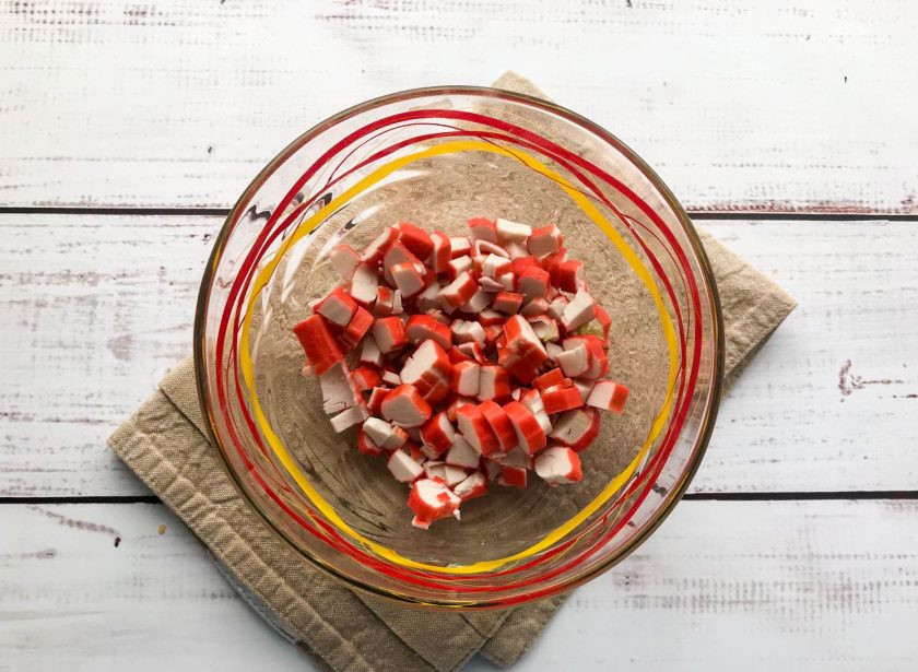 1. Этап. Крабовый салат со сметаной: Крабовые палочки нарежьте небольшими кусочками.