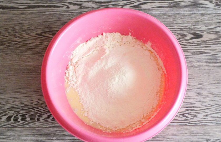 1. Этап. Синнабоны с малиной: Просейте муку. Добавьте частями в чашу и начните замес ложкой. Когда станет трудно перемешивать, месите руками.