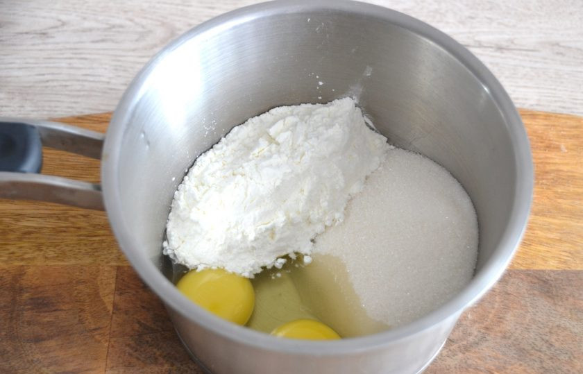 1. Этап. Крем Пломбир для эклеров: Начните приготовление эклеров с приготовления крема. Для этого выложите в сотейник 2 яйца, 150 грамм сахара, кукурузный крахмал, смешайте.