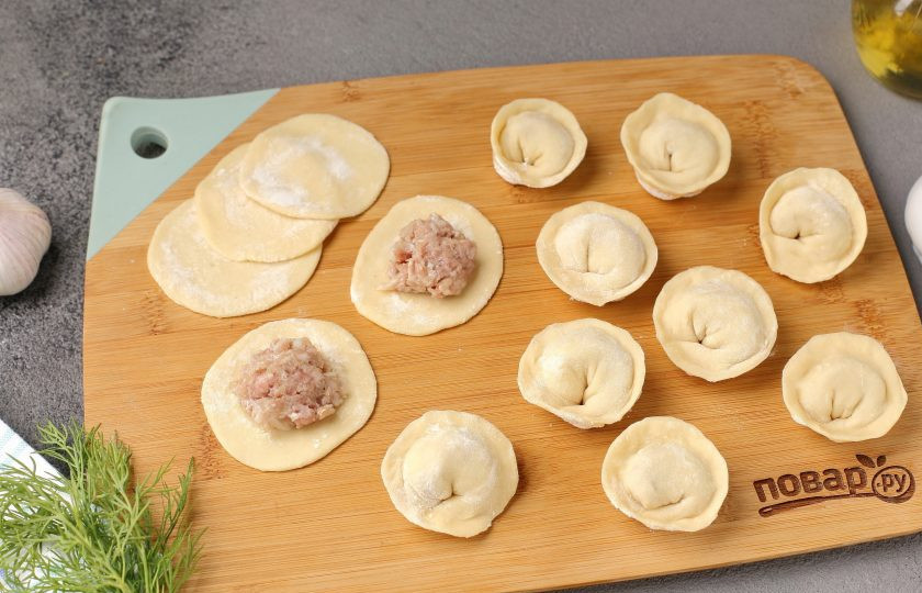 1. Этап. Сибирские пельмени с чесноком: Затем обваляйте каждый кусочек с двух сторон в муке и раскатайте в форме круга. По центру выложите начинку. Сформируйте пельмени любым удобным способом.