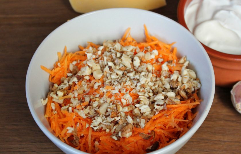 1. Этап. Салат Любовница с черносливом: Готовим морковный слой. Сырую морковь трем на терке и соединяем с колотыми грецкими орехами.