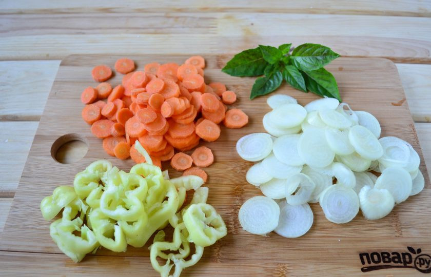 1. Этап. Помидоры с овощами в желе Ералаш: Лук нарежьте кружочками и разделите на кольца, морковь нарежьте кружочками, перец очистите от семян и плодоножки и нарежьте колечками или полукольцами.