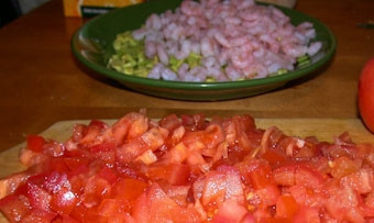 1. Этап. Салат из авокадо и креветок в лодочках: Помидоры ошпарьте кипятком. Снимите кожицу. Мелко нарежьте и посолите. Дайте им немного постоять, а затем слейте сок. Добавьте пропущенный через пресс чеснок. Смешайте с креветками и авокадо.