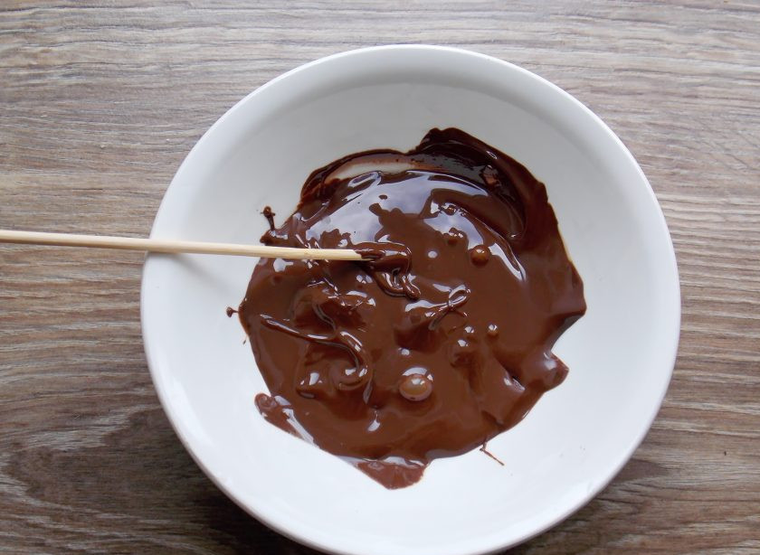 1. Этап. Кейк попсы из печенья: Растопите часть шоколада и окуните в него один конец палочки для кейк попсов.