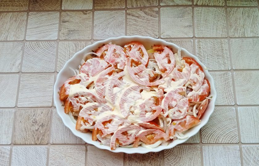 1. Этап. Курица по-французски с картошкой: Помидоры нарежьте кружками и разложите поверх лука. Смажьте майонезом. Поставьте в духовку разогретую до 180-185 градусов. Запекайте курицу 30-35 минут.