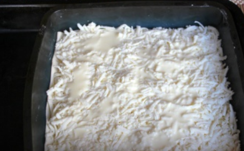 1. Этап. Ачма настоящая: Форму для запекания смазываем маслом. Выкладываем лист теста, сверху распределяем часть сыра и вливаем немного кефирной смеси. Таким же образом выкладываем оставшиеся листы теста и начинку.