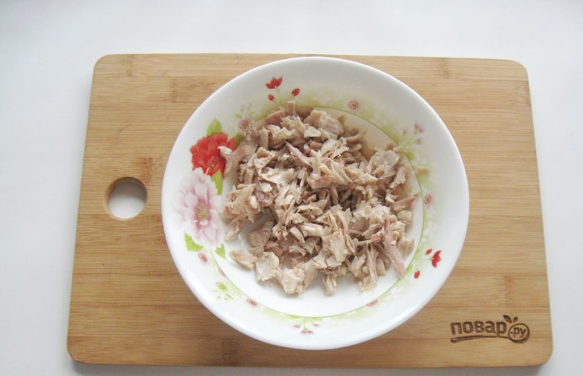 1. Этап. Салат Воронье гнездо: Нарежьте отварную курицу и выложите в салатник.