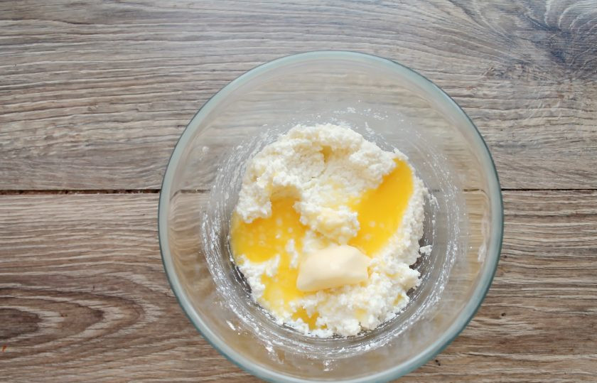 1. Этап. Глазированные сырки со сгущенкой: Сливочное масло растопите и влейте в миску с творогом. Пробейте все блендером до однородной массы.