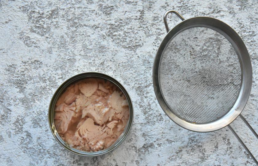 1. Этап. Салат с капустой, помидорами и тунцом: Откройте баночку с тунцом и слейте через сито жидкость (масло).