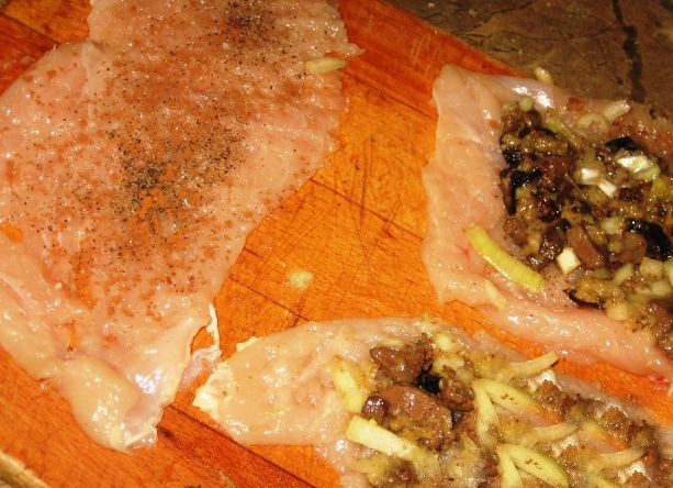 1. Этап. Куриные рулетики с начинкой из печени: Куриную грудку разрежьте на филешки. Отбейте каждую часть деревянным молотком, посолите, поперчите и посыпьте корицей. На куриные отбивные выложите слой подготовленной начинки, сверните рулетом.