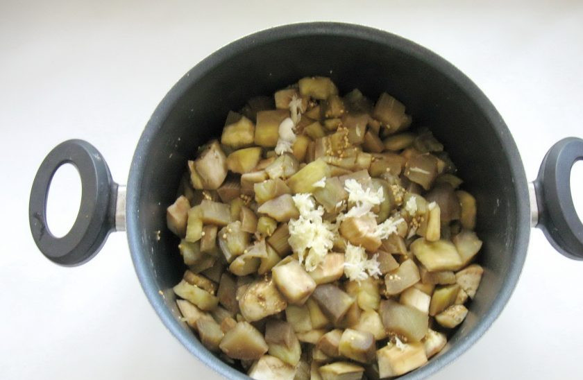 1. Этап. Закуска из баклажанов с помидорами на зиму: Варите баклажаны 10-12 минут до готовности. Воду из кастрюли слейте. Затем очистите чеснок, измельчите и отправьте к баклажанам.