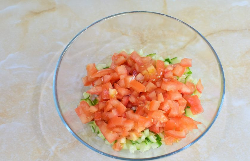 1. Этап. Крабовый салат с помидорами и огурцами: У помидора вырежьте место плодоножки. Нарежьте помидор, так же, на кусочки. Добавьте в чашу к салату.