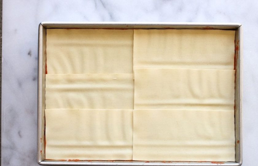 1. Этап. Вкусная лазанья: Возьмите прямоугольную форму для выпечки. Укладывайте слоями лапшу для лазаньи, соус с фаршем и сырную смесь.