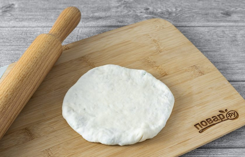 1. Этап. Лепешки с брокколи: Немного раскатайте лепешку. Придайте ей округлую форму.