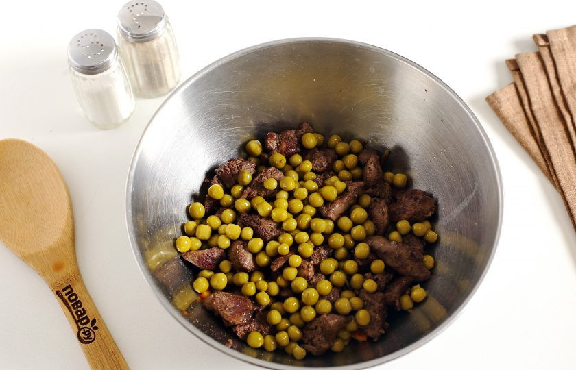 1. Этап. Салат из куриной печени: Переложите подготовленные ингредиенты в глубокую миску и добавьте консервированный зеленый горошек.