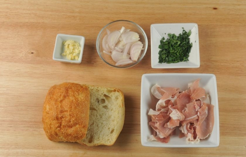 1. Этап. Букатини с ветчиной: 1. Подготовьте ингредиенты. Мелко нарубите чеснок и петрушку. Нарежьте полукольцами лук. Чиабатту разрежьте пополам. Прошутто нарежьте тонкими слайсами.