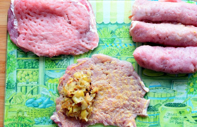 1. Этап. Свиные рулетики с яблоком: Смажьте отбитый кусок мяса горчицей, берите острые сорта. Выложите на один край ложку начинки и сверните в рулетик. Повторите со всеми отбивными. По желанию, можно обвязать рулетики нитками.