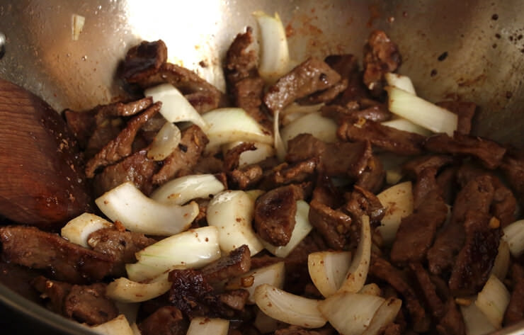 1. Этап. Говядина диетическая: 3. Добавьте в сковороду к мясу луковицу, имбирь и чеснок, перемешайте.