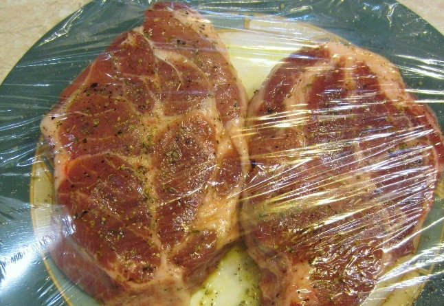 1. Этап. Стейк из шейки свинины: Упаковываем тарелку с мясом в пищевую пленку и оставляем мясо мариноваться примерно на 1 час.