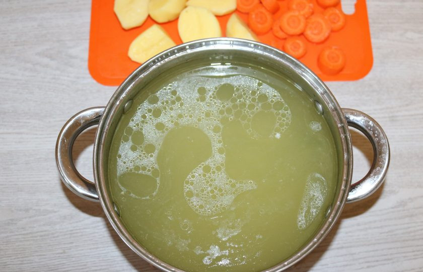 1. Этап. Татарский суп-лапша «Токмач»: Извлеките курицу из бульона. В кипящий бульон добавьте нарезанный картофель и морковь.