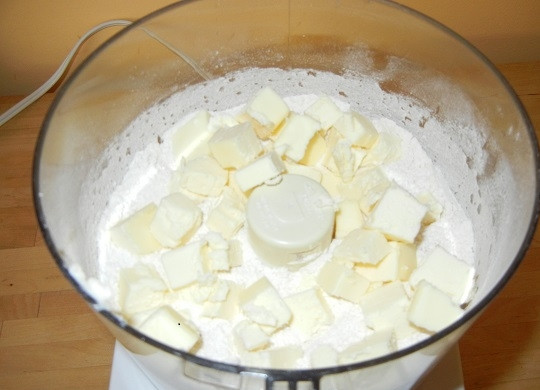 1. Этап. Рисовый пирог: 1. Первым делом нужно сделать тесто. В глубокую мисочку отправьте просеянную муку, сахар, щепотку соли и разрыхлитель. Перемешайте сухие ингредиенты и добавьте холодное сливочное масло.