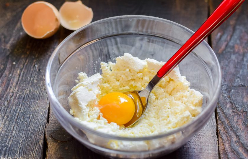 1. Этап. Сырники как в ресторане: Добавьте к творогу куриное яйцо.