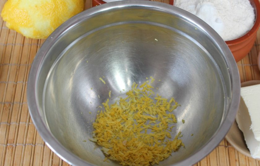 1. Этап. Песочное имбирное печенье: Снимаем цедру с одного лимона и высыпаем в миску.