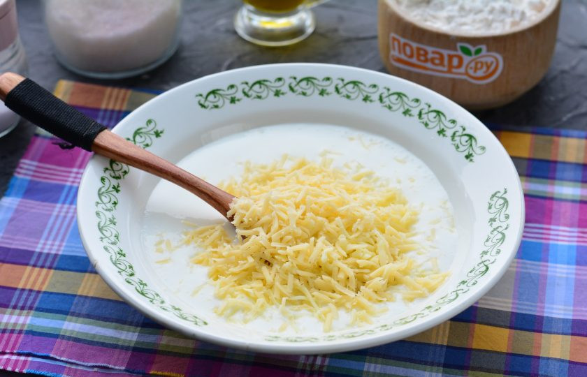 1. Этап. Оладьи с сыром на кефире: Натрите сыр и всыпьте в тесто.