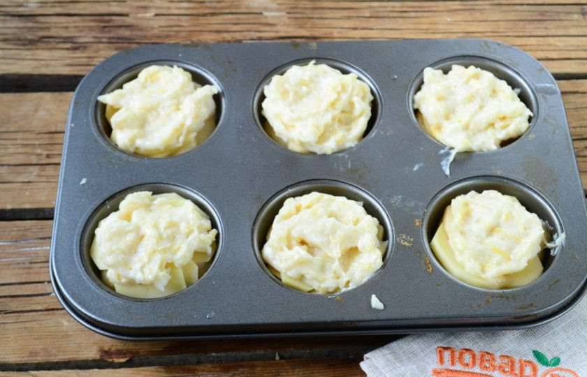 1. Этап. Гратен из картофеля в стиле маффинов: Сверху положите примерно по 1 ст. ложке соуса, затем положите снова картофельные слайсы, которые снова покройте сливочным соусом. Все должно быть примерно вровень с бортами формы, чтобы при запекании соус не растекся.