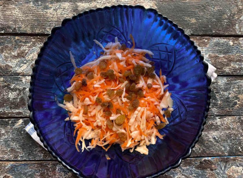 1. Этап. Квашеная капуста с изюмом: На дно посуды где будет кваситься капуста положите два капустных листа, затем выложите половину капусты, а на капусту выложите изюм.