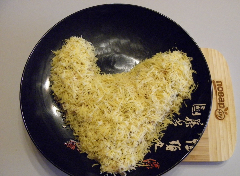 1. Этап. Салат Золотой петушок: Оформите тело петушка тертым сыром. Я использовала самую мелкую терочку.