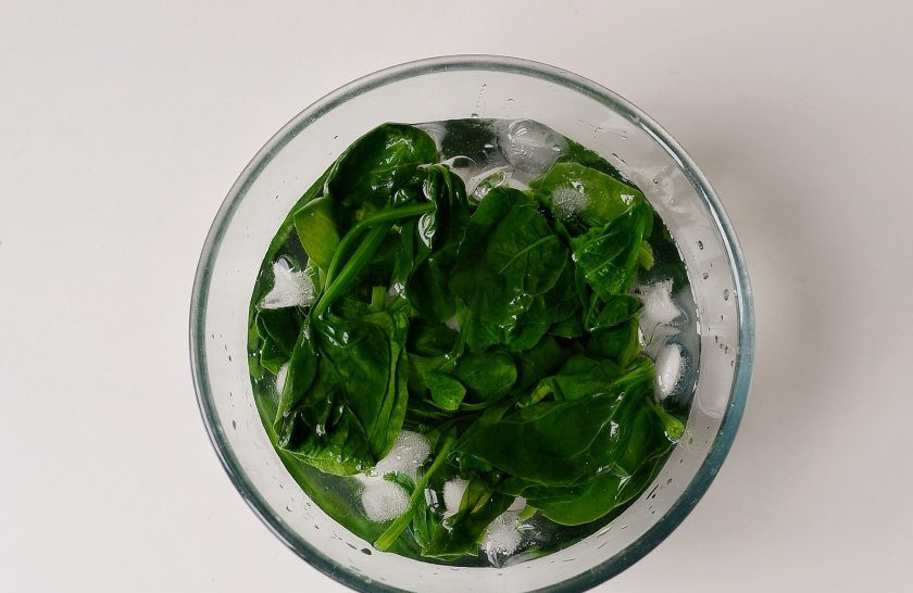 1. Этап. Палак панир с тофу: Шпинат помойте, отварите в кипящей воде 1-2 минуты. Затем опустите шпинат в заранее подготовленную миску с холодной водой и кубиками льда (это поможет сохранить яркий зеленый цвет шпината). Откиньте шпинат на дуршлаг.