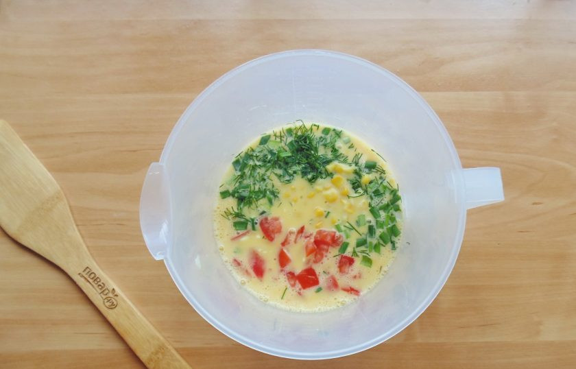 1. Этап. Рулет из омлета с овощами: Выложите в миску нарезанные кубиками помидоры без семян и консервированную кукурузу.