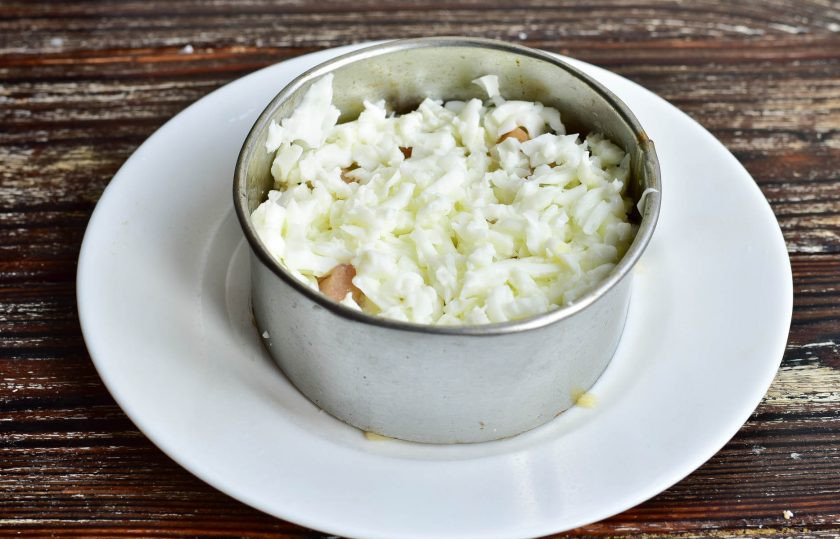 1. Этап. Салат Чебурашка с курицей: На мясо выложите натертые на крупной терке яичные белки.